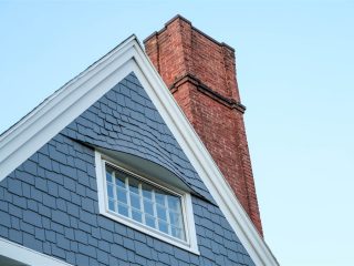 New window on historic building with brick chimney.