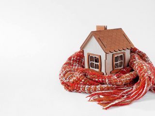small house wrapped in scarf following home winterization checklist