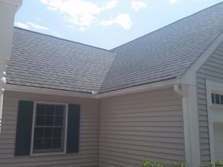 GAF Asphalt Roofing on a home with beige siding and green shutters.